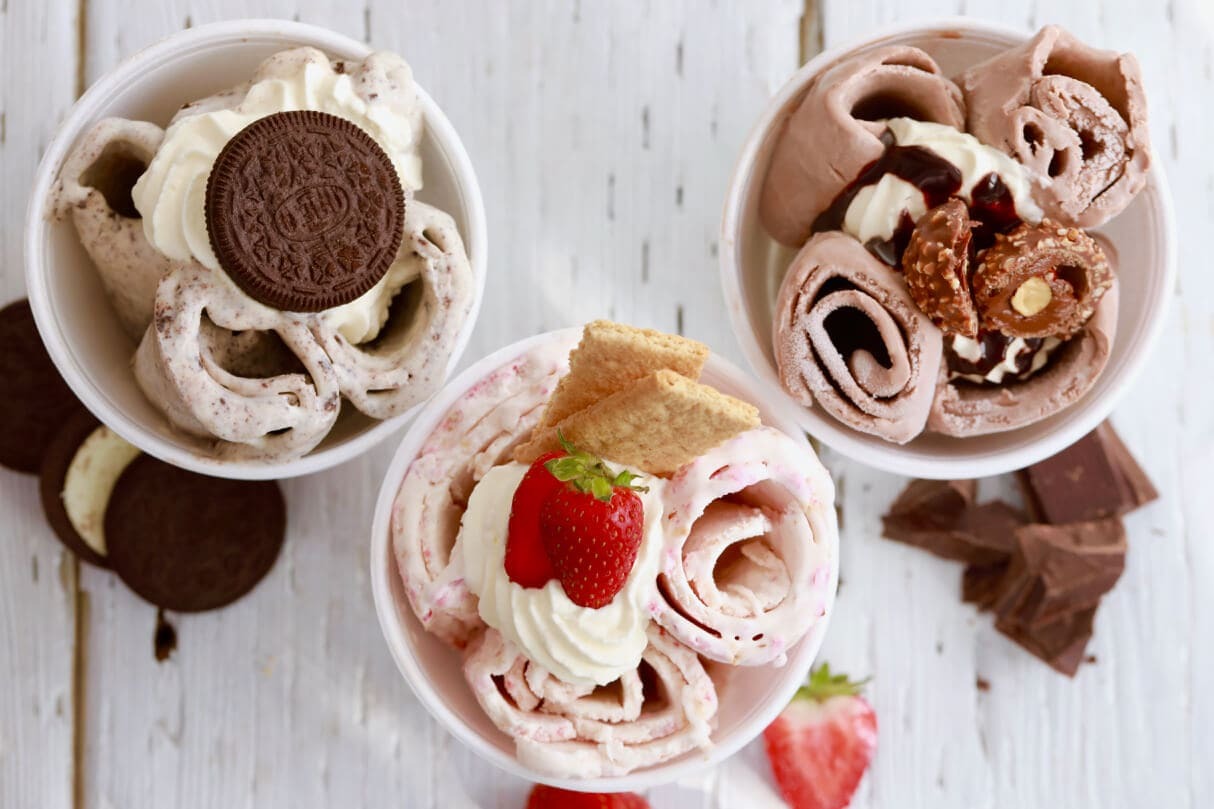 Rolled ice cream topped with cookies, drizzle, and crunchy add-ons